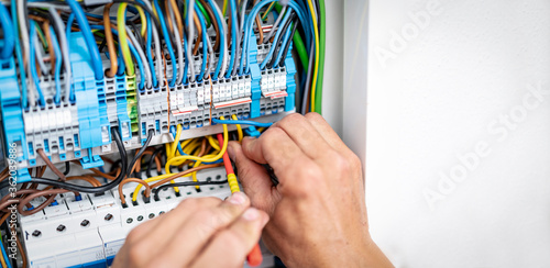 Elektriker arbeitet am Sicherungskasten eines Hauses