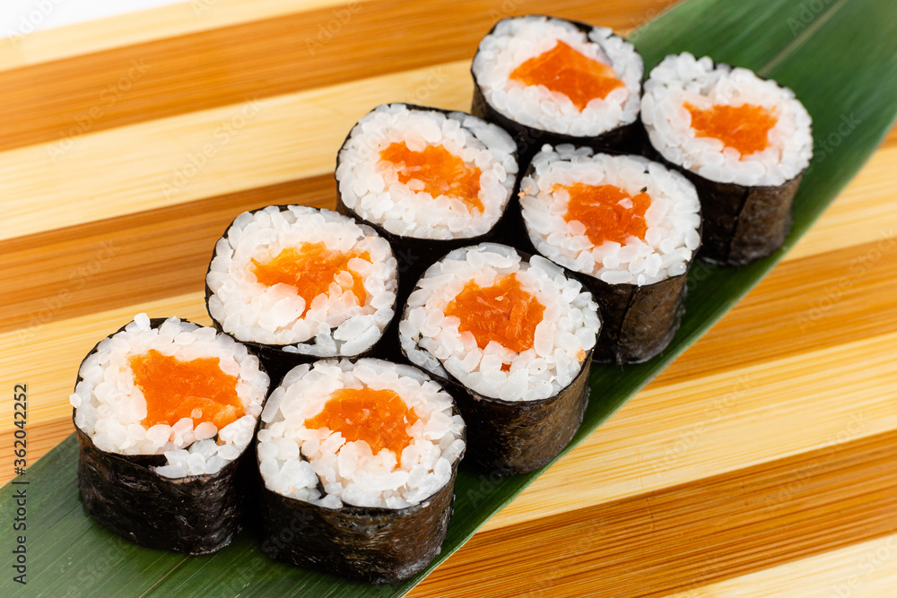 Maki Sushi Rolls set on wooden bamboo board. Japanese traditional Cuisine. White background. Maki Sushi Rolls set on wooden bamboo board. Japanese traditional Cuisine. White background.