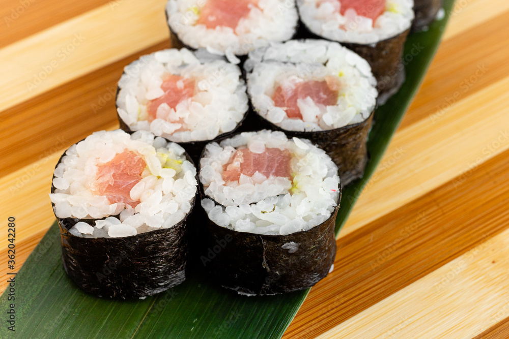 Maki Sushi Rolls set on wooden bamboo board. Japanese traditional Cuisine. White background. Maki Sushi Rolls set on wooden bamboo board. Japanese traditional Cuisine. White background.