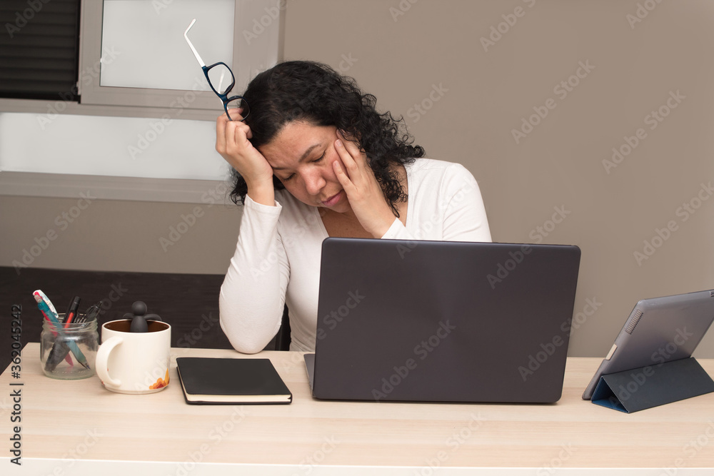 Young caucasian woman with glasses and a white shirt tired from working with her laptop Young caucasian woman with glasses and a white shirt tired from working with her laptop