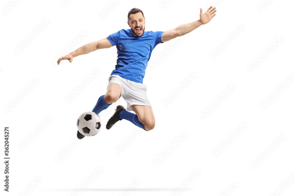 Footballer jumping and kicking a ball