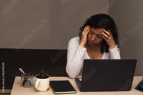 Young caucasian woman with glasses and a white shirt tired from working with her laptop