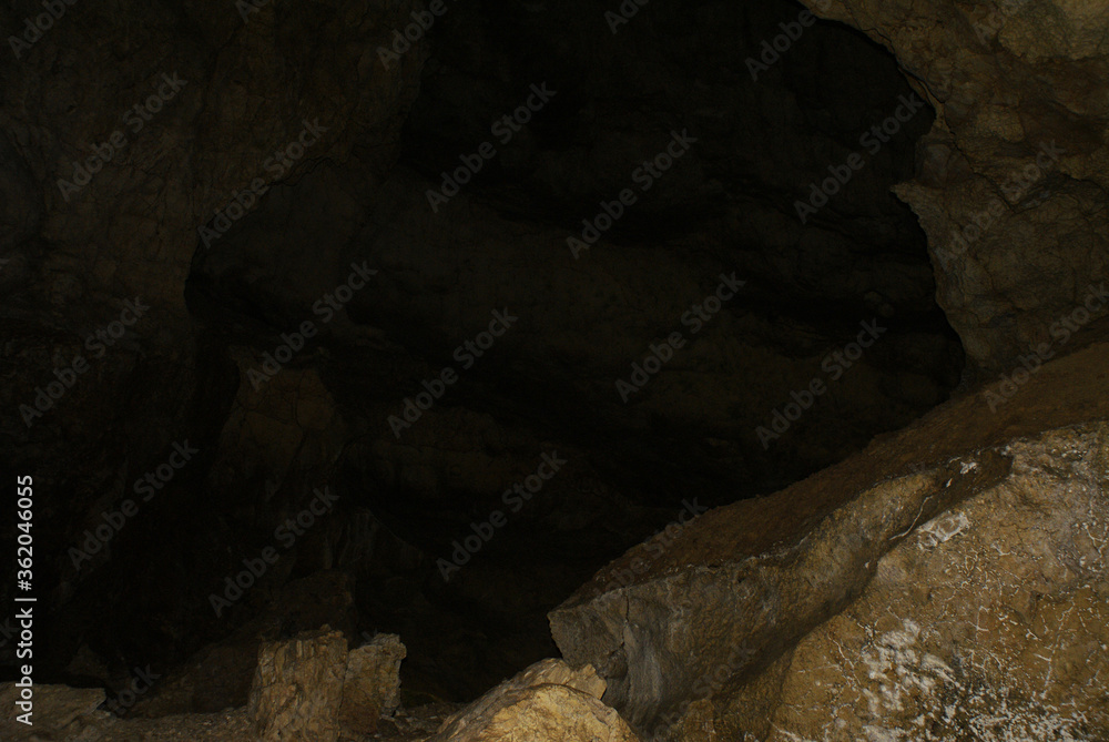 Obraz premium A cave with stalactites and stalagmites in an underground cave, rocks.