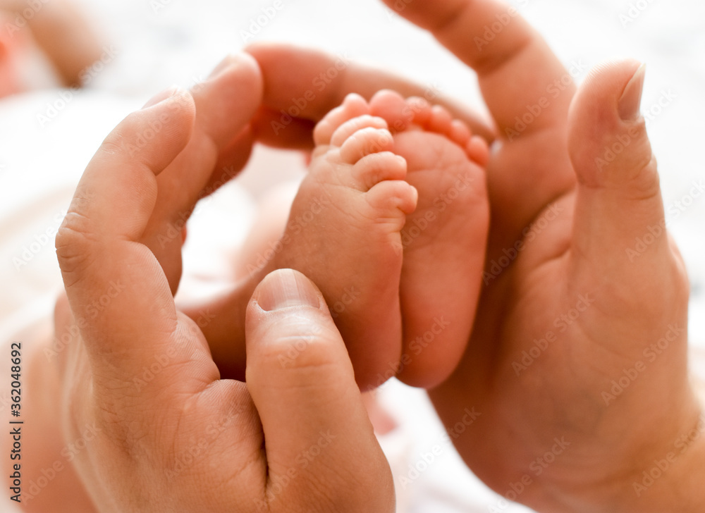 The father holds the baby's legs. Newborn in the hands of the Pope. Small children's feet, men's hands. Greeting card for father's day. The father holds the baby's legs. Newborn in the hands of the Pope. Small children's feet, men's hands. Greeting card for father's day.