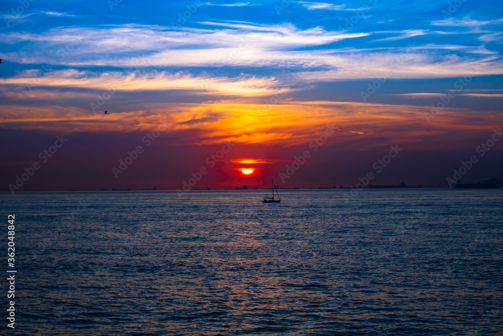 Fototapeta premium Sunset over the sea and a boat