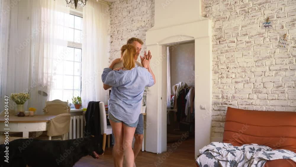 beautiful couple is dancing and having fun at their apartment with their dogs beautiful couple is dancing and having fun at their apartment with their dogs