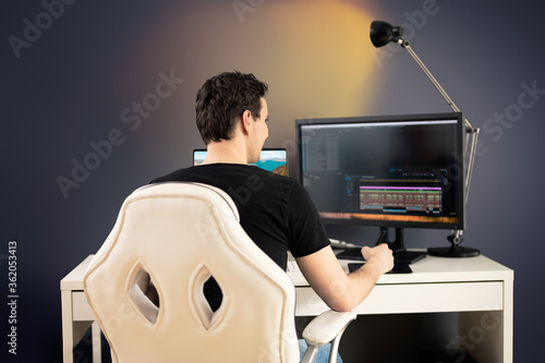 фотографія freelance video editor sit on white chair and desk in his office and cut some vi