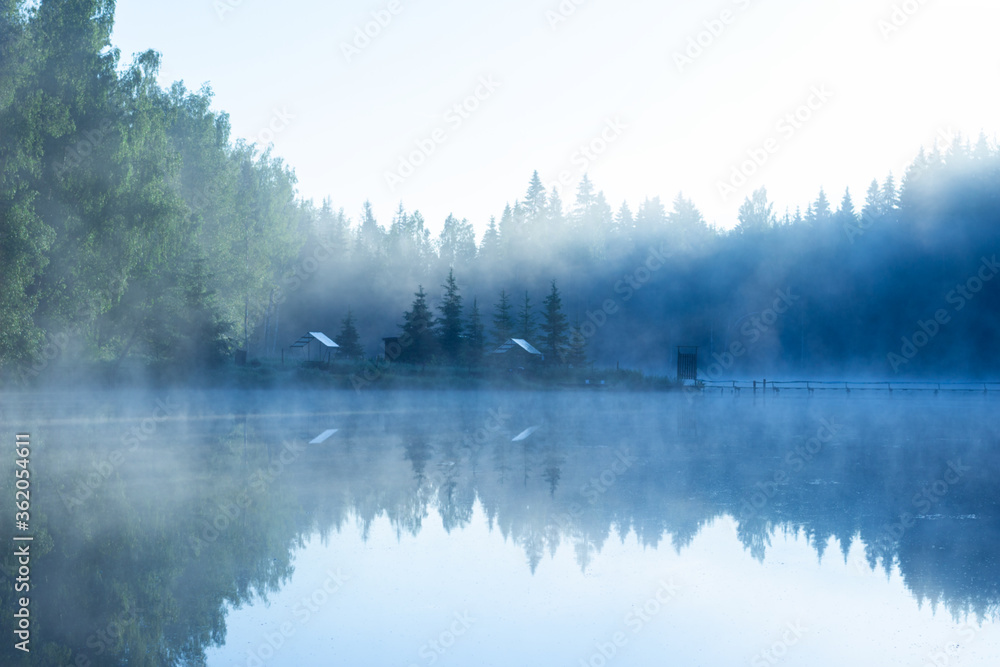 fog on the lake at dawn, forest and gazebos can be seen in blur fog on the lake at dawn, forest and gazebos can be seen in blur
