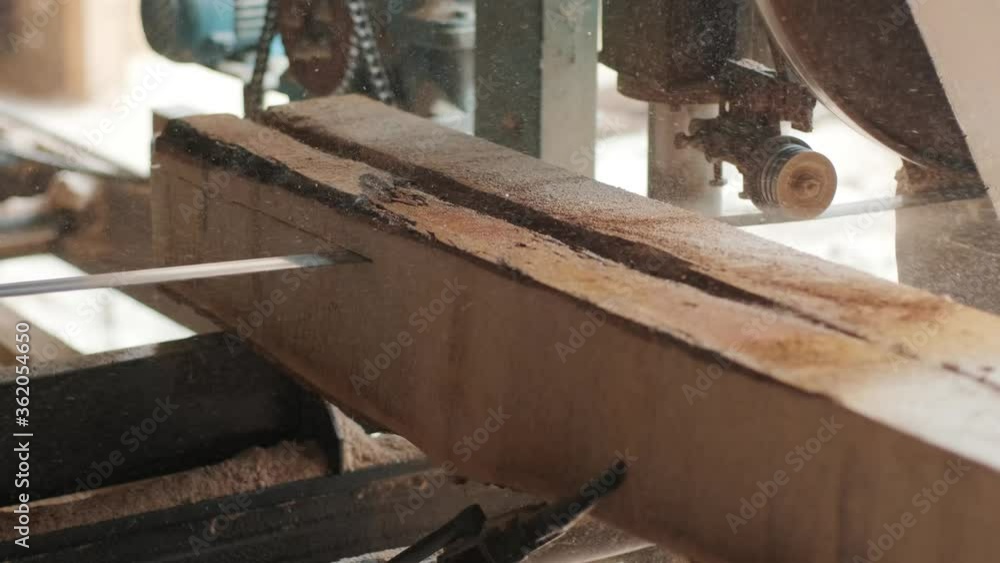 Sawing machine at wood production factory. Timber material processing and cutting at sawmill. Manufacturing process at lumber mill. Sawing woods on power machine. CNC machine Sawing machine at wood production factory. Timber material processing and cutting at sawmill. Manufacturing process at lumber mill. Sawing woods on power machine. CNC machine
