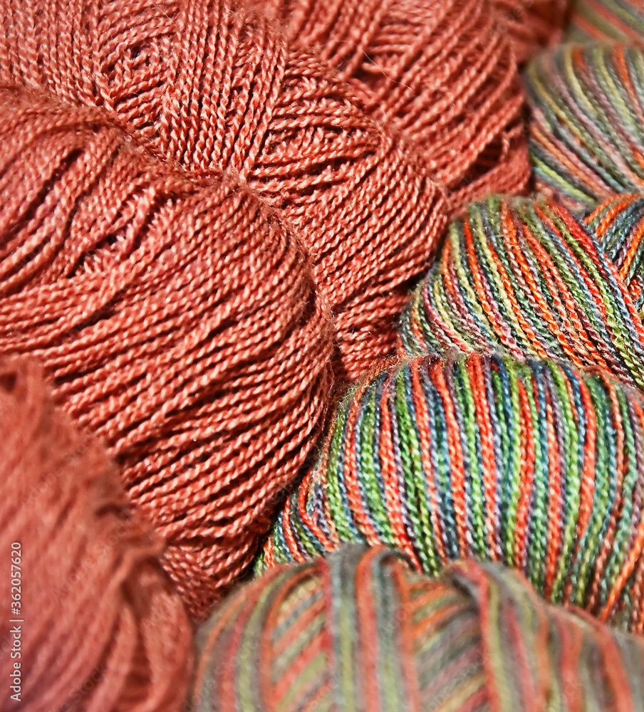 Two closeup skeins of salmon colored yarn are next to each other, one