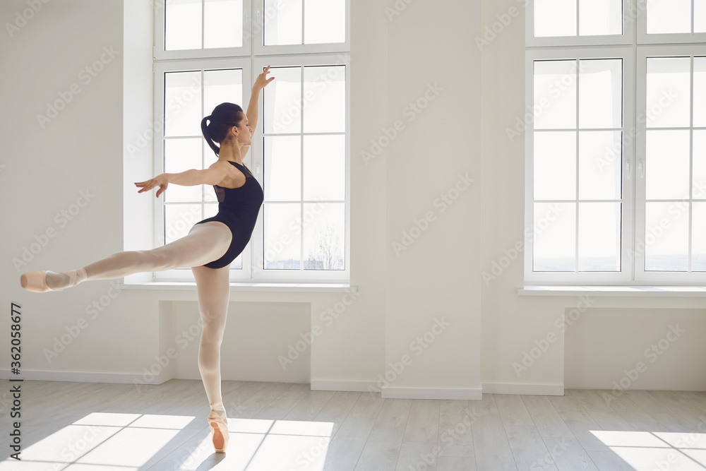 Ballerina. Young graceful ballet dancer is rehearsing a performance in a white studio with windows. Ballerina. Young graceful ballet dancer is rehearsing a performance in a white studio with windows.