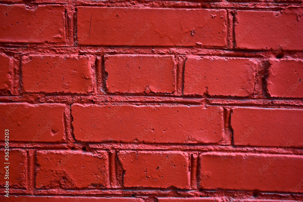 Obraz premium The wall of red-painted brick building in the city