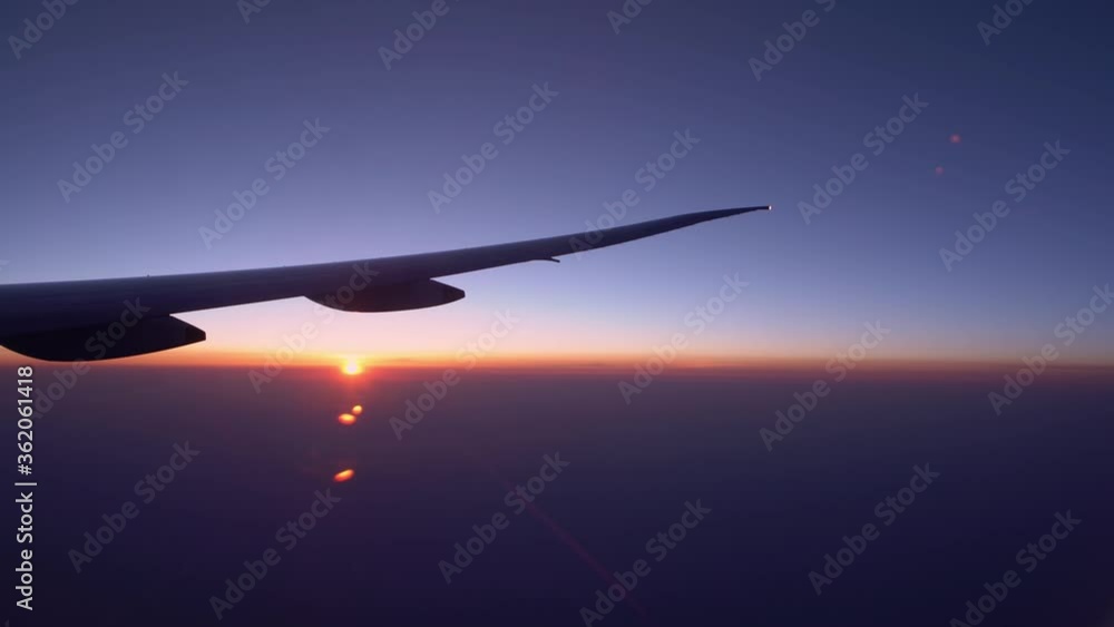 4K, Wonderful dusk light from above, as seen through airplane window. View of plane wing with sunset in flight trip, traveling by air. Vacation journey concept-Dan 4K, Wonderful dusk light from above, as seen through airplane window. View of plane wing with sunset in flight trip, traveling by air. Vacation journey concept-Dan
