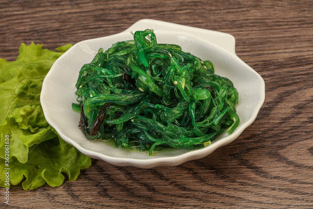 Green Chuka Seaweed Salad Isolated on White Background Top View. Wakame Sea Kelp Salat Green Chuka Seaweed Salad Isolated on White Background Top View. Wakame Sea Kelp Salat