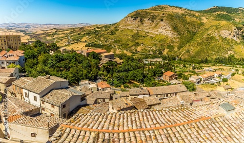 A view over the rooftops of the hilltop village of Petralia Sottana towards the limestone peaks of the Madonie Mountains, Sicily during summertime