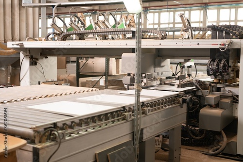 Conveyor belt with chipboard parts on factory