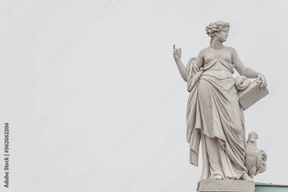 Old roof statue of a Renaissance Era woman philosopher and poet with book and chicken in Potsdam at white creamy background and copy space for text, Germany - obrazy, fototapety, plakaty 