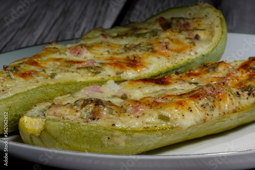two halves of stuffed zucchini with cheese, bacon and green onion