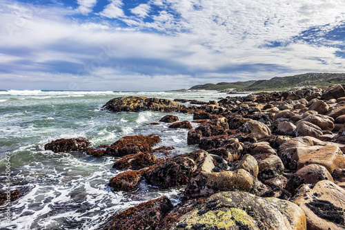 Picturesque view of the rocky shoreline of Atlantic Ocean and Platboom Beach. Platboom Bay is a beautiful beach along coastline nestled in Cape of Good Hope Nature reserve, Cape Town, South Africa. photo