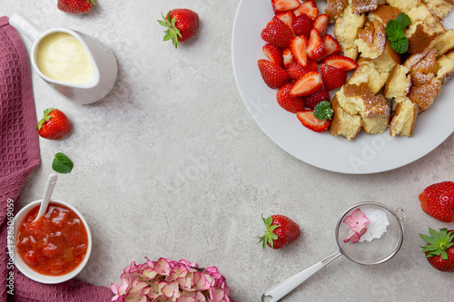 Kaiserschmarren or Kaiserschmarrn, traditional Austrian or German sweet pancake dessert, with berry, strawberry jam or rote grutze and vanilla pudding sauce. Top view. Copy space. photo