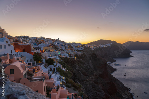 Oia town on Santorini island in Greece. The background is a blue sky with dark clouds. View of white houses