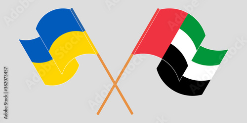 Crossed and waving flags of the Ukraine and the United Arab Emirates