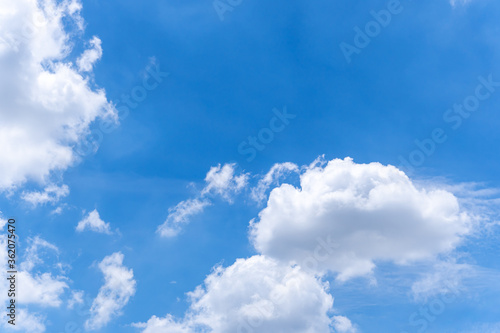 White clouds on bright blue sky in sunny day.