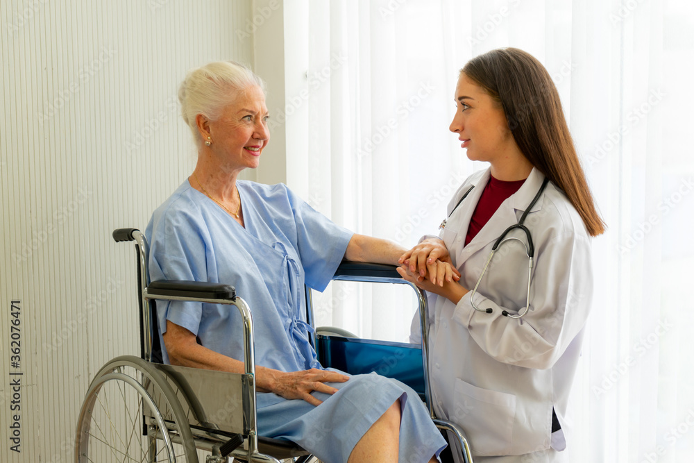 Obraz premium caucasian medical doctor physician diagnosed senior citizen femal patient on wheelchair in the hospital