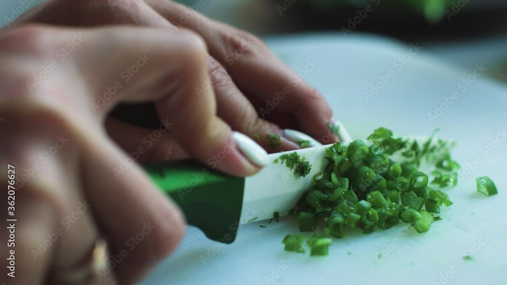 Slicing onions on a white board, female hands taken from close up in slow motion. Slicing onions on a white board, female hands taken from close up in slow motion.