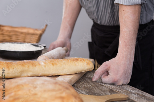 Georgian pita in male hands. Breaking bread. Kitchen view 