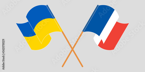 Crossed and waving flags of Ukraine and France