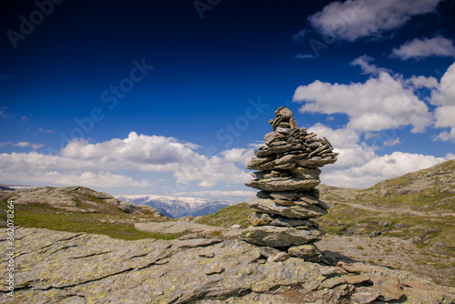 stones piled like a pyramid on a rock. Stones in the mountains against the blue sky. Stone structure © NatBud