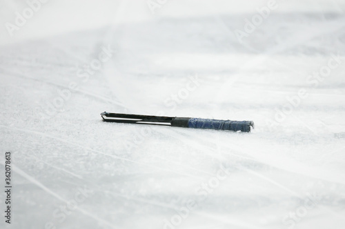 Photography A closeup of a small piece of broken ice hockey stick laying on the ice