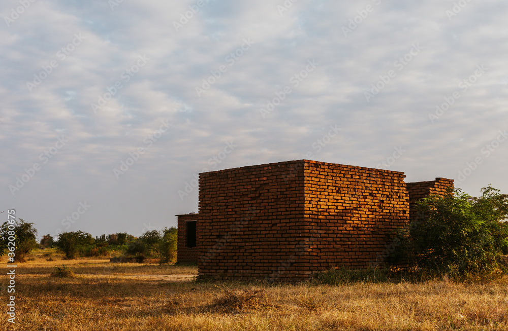 An unfinished brick house in the rural scene with blue sky