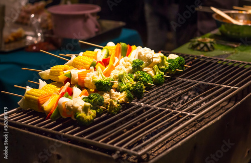 Barbecue skewers on the grill are sold to customers at the market.