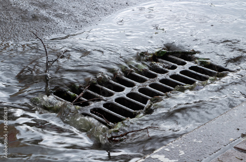 Rainwater flows into a storm sewer. City sewage system. photo