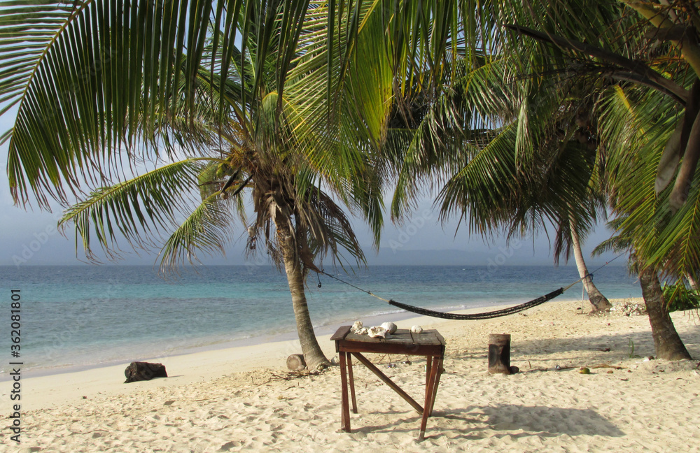 Hamacas en playa tropical con el mar de fondo