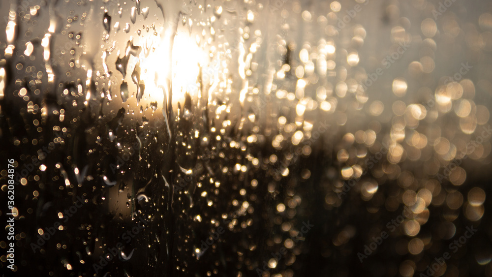 small drops on the window glass after rain. close-up photograph of a wet window at sunset.