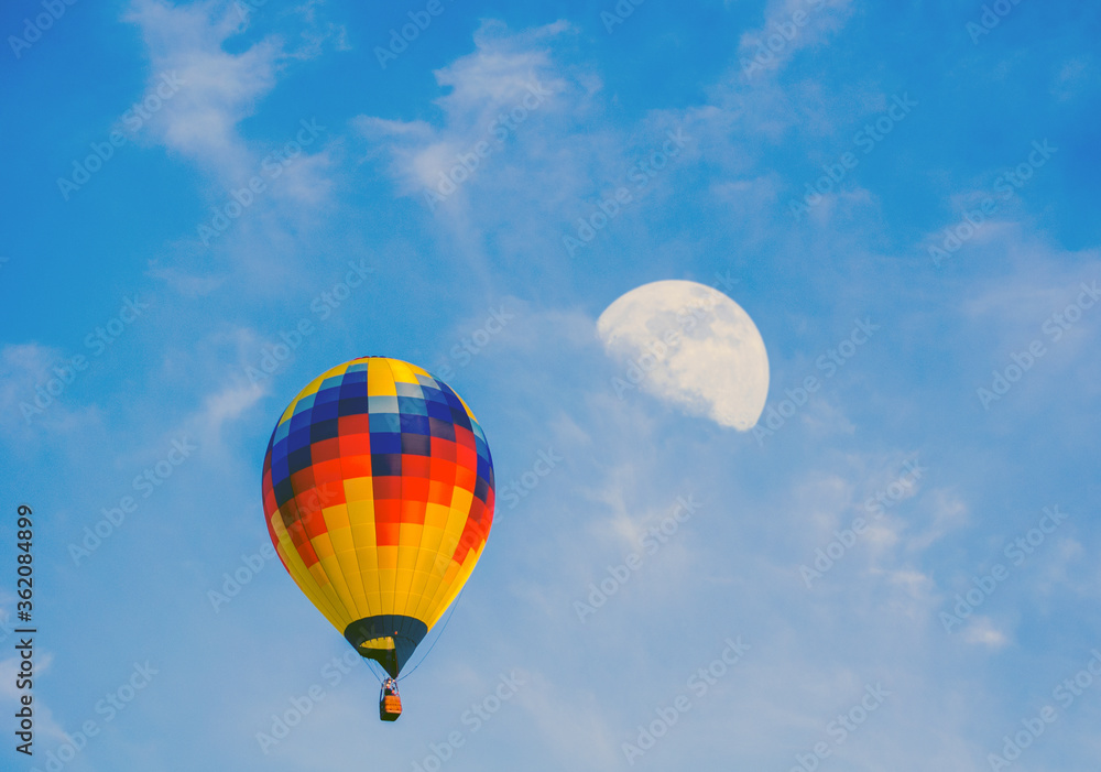 Fototapeta premium Hot air balloon in the sky appears to be flying to the moon