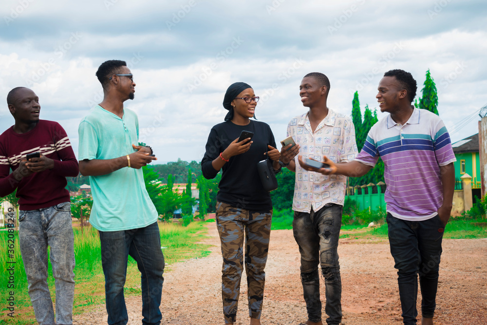 young black friends taking a stroll and checking out things on their smartphones young black friends taking a stroll and checking out things on their smartphones