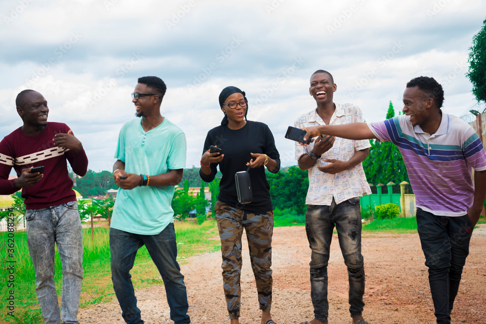 young black friends taking a stroll and checking out things on their smartphones young black friends taking a stroll and checking out things on their smartphones
