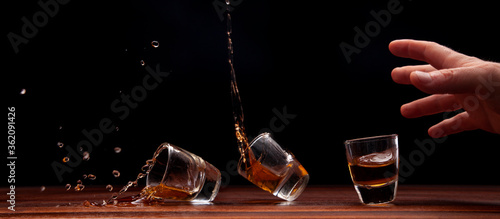 Shot glass of whiskey tipping over

