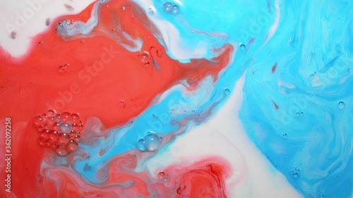 Red white and blue background or screensaver, blue and red food coloring on a white plate with milk