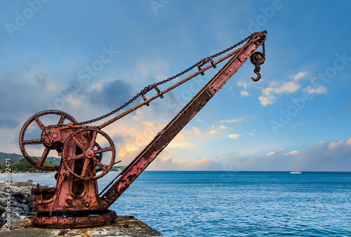 Old Red Rusty Crane by Sea at Dusk