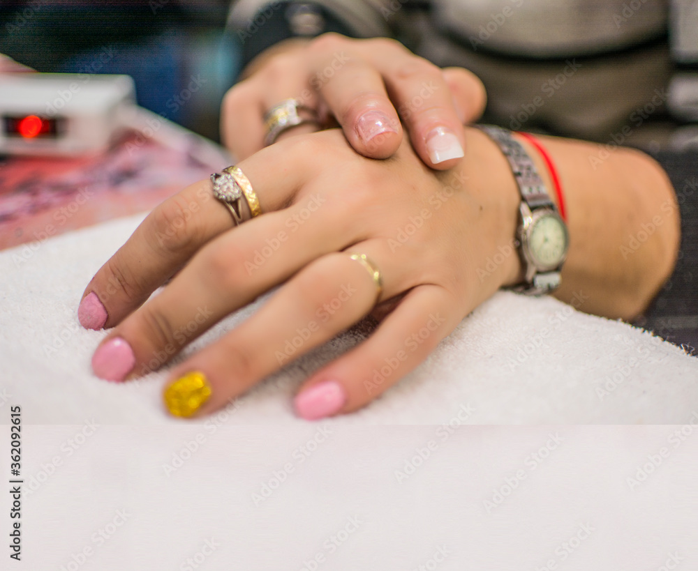 Beautiful semi-permanent manicure nails. Light manicure in light on a white background in a beauty salon Beautiful semi-permanent manicure nails. Light manicure in light on a white background in a beauty salon