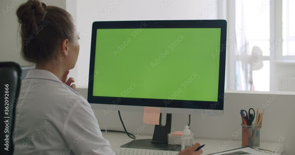 Doctor work on computer with green mock-up screen Doctor work on computer with green mock-up screen