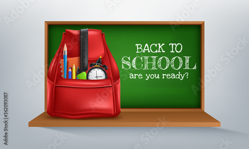 Back to School on green chalkboard, student supplies and classroom items on desk