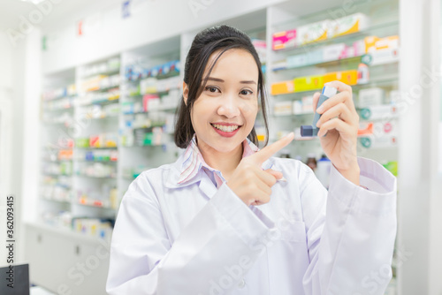asian female pharmacist explain about how to use inhaler medicine, asthma clinic, she holding inhaler medicine with her hand