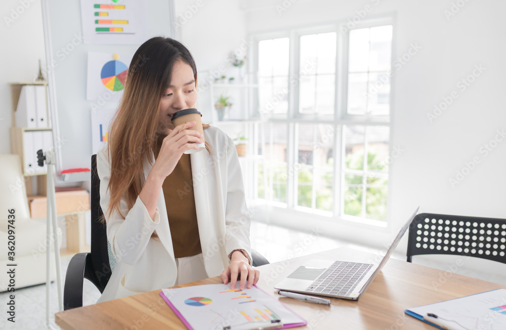 attractive asian officer rest on a seat in workplace, she holding and drinking hot coffee in paper cup, she feeling happy in relax time, happiness organization attractive asian officer rest on a seat in workplace, she holding and drinking hot coffee in paper cup, she feeling happy in relax time, happiness organization