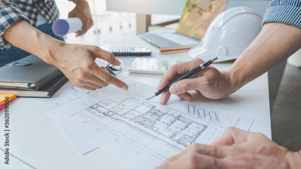engineer Hand Drawing Plan On Blue Print with architect equipment discussing the floor plans over blueprint architectural plans at table in a modern office. engineer Hand Drawing Plan On Blue Print with architect equipment discussing the floor plans over blueprint architectural plans at table in a modern office.
